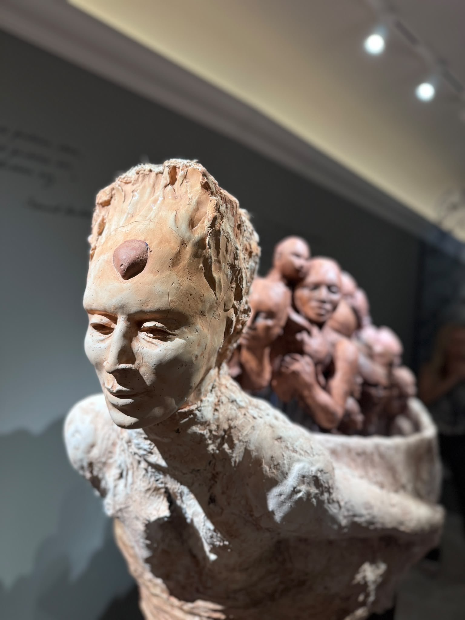 Ceramic sculpture of a figure carrying faces at Nit de l'Art Palma