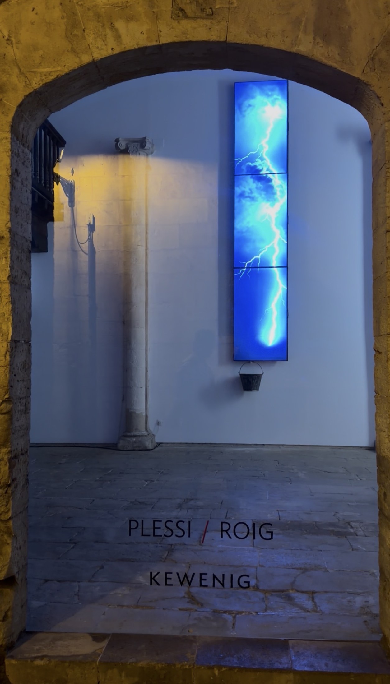 Blue neon light installation glowing in a stone archway, Plessi Roig exhibition at Kewenig
