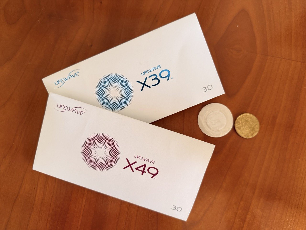 LifeWave X39 and X49 phototherapy patch packs on a wooden table