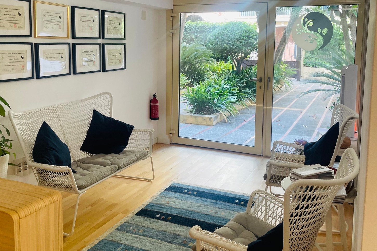 Light-filled reception at MIKU Mallorca Clinic of Integrative Medicine, home of Sacred Space Palma, opening onto a garden courtyard in Palma