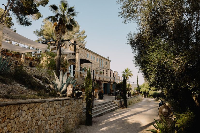 Stone finca with palm trees, agave and olive trees at Osa Major retreat venue, Mallorca